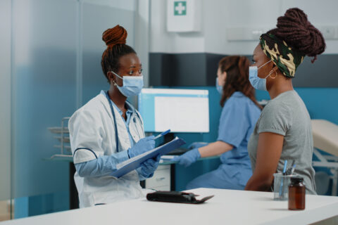 Doctor and patient with face masks talking about disease